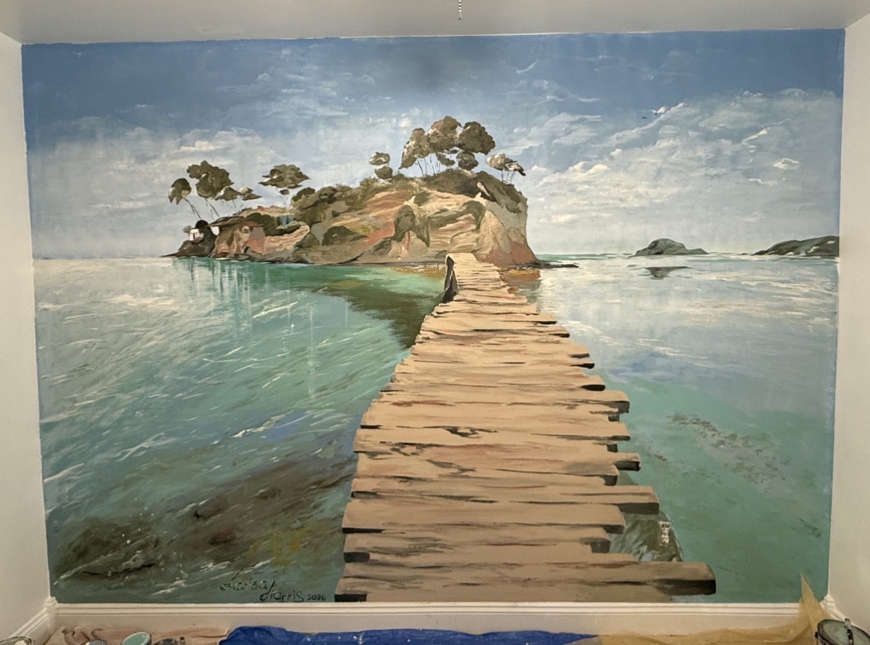 A hand-painted mural of a wooden pier extending across calm turquoise water toward a small island.
